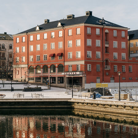 	Kvarteret Castor i Södertälje, röd flervåningsbyggnad som ligger vid vattnet.
